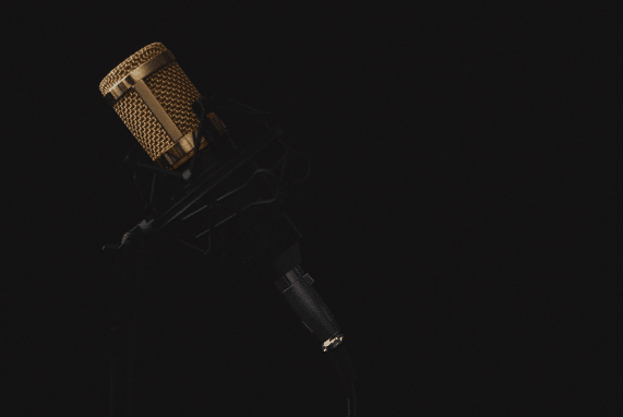 Public service announcement, image of a a gold microphone, black background